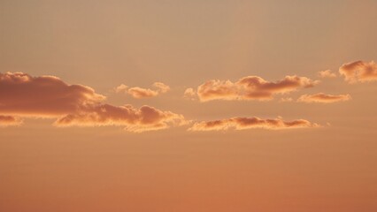 Wall Mural - Morning horizon illuminated by warm golden light with orange and yellow clouds, summer dawn sky background