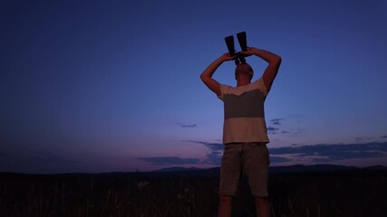 Wall Mural - amateur astronomer using binoculars for watching stars, moon, planets and other celestial objects fr