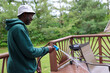 © Robin - A Portrait Of A Black Man Power Washing A Wooden Deck