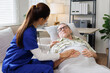 © David - Friendly Head Nurse Caring for a old man patient lying in bed medical and healthcare concept