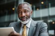 © Serhii - Confident Mature Businessman Engaging with Tablet in Modern Office Setting