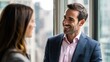 © tow - Colleagues sharing a smile in professional clothing with window light, perfect for team-building visuals, corporate photography alternatives, or workplace harmony content.