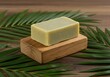 © Fernando Sanso - Light-colored natural soap bar on wooden tray with fresh palm leaves, highlighting organic beauty products and sustainable skincare for healthy lifestyle.