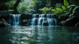 Serene waterfall cascading over rocks into a calm river surrounded by lush green tropical trees and plants.