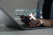 © MUNTHITA - Technical support operator with virtual screen icon working on laptop computer. Help desk IT support call center online technology. Customer service and business warranty quality assurance concept.