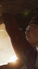 Sticker - animation of glowing light over woman working in car workshop