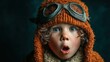 © Komputer - Close-up portrait of a child wearing an aviator costume, eyes wide with surprise