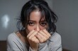 © Iftikhar alam - Young Asian woman expressing anxiety and unhappiness while covering her face with her hands in a simple indoor setting during the day