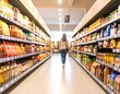 © BoniTuah - A soft-focused grocery aisle with full shelves and a person walking away, adding motion and depth to the calm store setting.