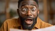 © SY - Bearded African man with glasses, eyes wide, mouth open in shock. Great for depicting surprise, awe, or unexpected positive news.
