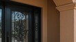 © AkuAku - Black entryway door with a detailed wrought-iron storm door incorporating glass below, enhanced by a transom window positioned close to the right-side window.