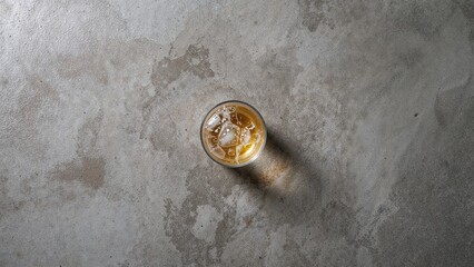 Wall Mural - overhead shot of a beer glass casting shadows on a gray concrete surface with empty space, minimalis