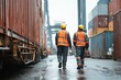 © Pacharee - Two workers in safety gear walking in a container yard at an industrial port.