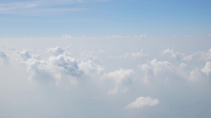 Wall Mural - Aerial view of puffy white cloud over clear blue sky while flying in airplane, Airplane flight flying above the clouds. View from the window of the plane traveling by air, natural background concept