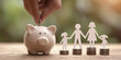 © Tu - businessman putting coin on the piggybank and paper family on table, donation, saving, charity, family finance plan concept, fundraising, superannuation, investment, financial crisis concept.
