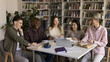 © fizkes - Collaborative education with fun. Diverse group happy university students from different ethnic backgrounds study together at library table smile discuss books share ideas on creative learning session