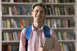 © fizkes - Confident modern learner. Portrait happy smiling student guy zoomer with trendy dyed hair look at camera in library wear backpack hold digital tablet prepared for academic success exploring knowledge
