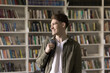 © fizkes - Education for successful life start. Happy smiling young male student with backpack stand in classroom near bookshelves look aside enjoy good academic results inspired by knowledge new opportunities