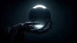 © Andrii - Metallic robotic hand holding a glowing crystal sphere in a dark futuristic environment.