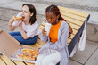 © Iryna - Girls enjoy pizza and coffee during outdoor lunch break