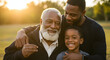 © Muhammad - Three generations of a Black family smiling together outdoors at sunset enjoying family time togetherness love happiness heritage