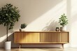 © Nice Seven - A stylish wooden cabinet with plants on either side, casting shadows on a light wall, creating a serene and modern interior atmosphere.