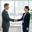 © Tegar Ramadhani - Diverse Business Partners Finalize Agreement with a Handshake in a Bright, Modern Office