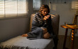 © Parichat - Young woman warming her hands while sitting on armchair covered with blanket