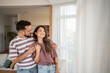 © Migma_Agency - Happy couple embracing and smiling in modern living room