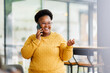 © David - african american woman entrepreneur busy with her work in the office. african american woman work on desk laptop phone while planning sales, research or financial strategy in company