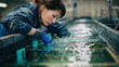 © Katerina - Aquaculture technician inspecting water quality in indoor fish tank facility