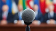 © Chaiwit - International tariff policy, Microphone in focus with blurred international conference background showing tariff and policy discussion