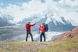 © Soloviova Liudmyla - Smiling each other backpackers couple with backpacks give high fives during Lenin peak ascent with mountain peaks in background. Extreme active people, high-altitude Pamir area mountaineering concept
