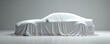 © Pete - Modern car covered with white sheet, hinting at new automotive technology, design. Clean, minimalist studio presentation suggests futuristic luxury sedan launch. Smooth, elegant drape emphasizes