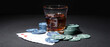 © Pixel-Shot - Poker chips, glass of beverage and cards on dark background