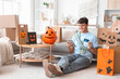 © Pixel-Shot - Young man with credit card and tablet computer shopping online for Halloween at home