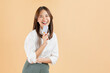 © sitthiphong - Cheerful beautiful Asian woman holding credit card isolated on beige color background.