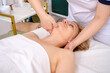 © kuzenkova - Serene lady lies on her back, she receives facial massage