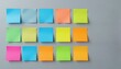 © Aliona - Brightly colored sticky notes in multiple rows and columns arranged neatly on a grey surface, useful for organization and planning.