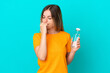 © luismolinero - Young Romanian woman with a bottle of water isolated on blue background having doubts