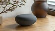 © Puri - Gray orb-shaped speaker on light wooden surface