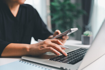 Close-up scene, a female seated at a table holds a smartphone, spending time on modern e-date services and social media through a mobile app, illustrating the wireless concept of digital usage.