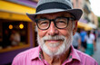 © starush - A smiling elderly man wearing glasses and a hat outdoors on a lively city street