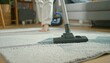 © Drago - Housekeeper vacuuming carpet in modern living room