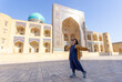 © LT - woman as a tourist have fun in front of Poi-Kalyan Kalyan mosque in bukhara Uzbekistan
