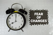 © may1985 - Fear Of Changes text with alarm clock on gray background