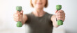 © Prostock-studio - Home sports during covid lockdown. Senior woman doing fitness exercises with weights indoors, focus on hands holding dumbbells. Mature lady strengthening her arm muscles, leading healthy lifestyle