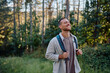 © we.bond.creations - Happy hiker breathing in fresh air while enjoying a trekking day in the serene woods, embracing the beauty of nature and adventure