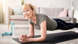 © Prostock-studio - Home training concept. Smiling senior woman doing elbow plank on yoga mat in living room. Positive mature lady doing her workout routine, exercising indoors, strengthening her core muscles