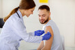 © Prostock-studio - General practitioner vaccinating young male patient, making covid-19 vaccine injection at clinic. Happy millennial guy receiving protection against coronavirus, participating in immunization campaign